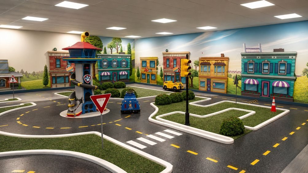 Kids driving vehicles on a themed town circuit